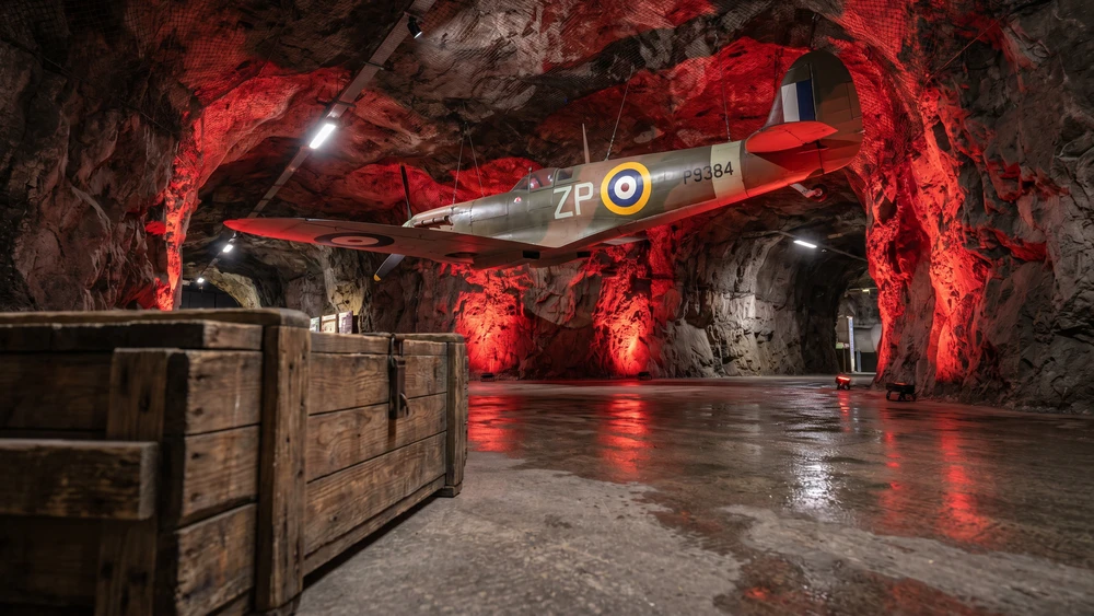 A replica Spitfire aircraft suspended inside Spitfire Hall within Gibraltar's WWII Tunnels