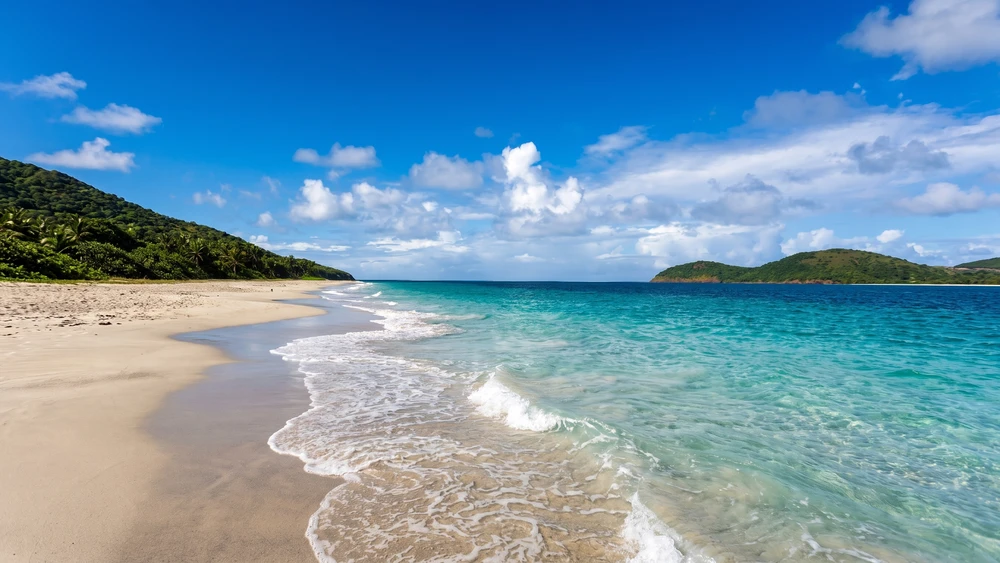 Empty white sand shoreline at Zoni Beach in Culebra with turquoise water and outlying islands visible